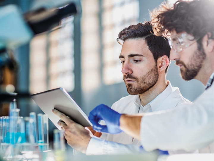 oncology researchers viewing results on a tablet