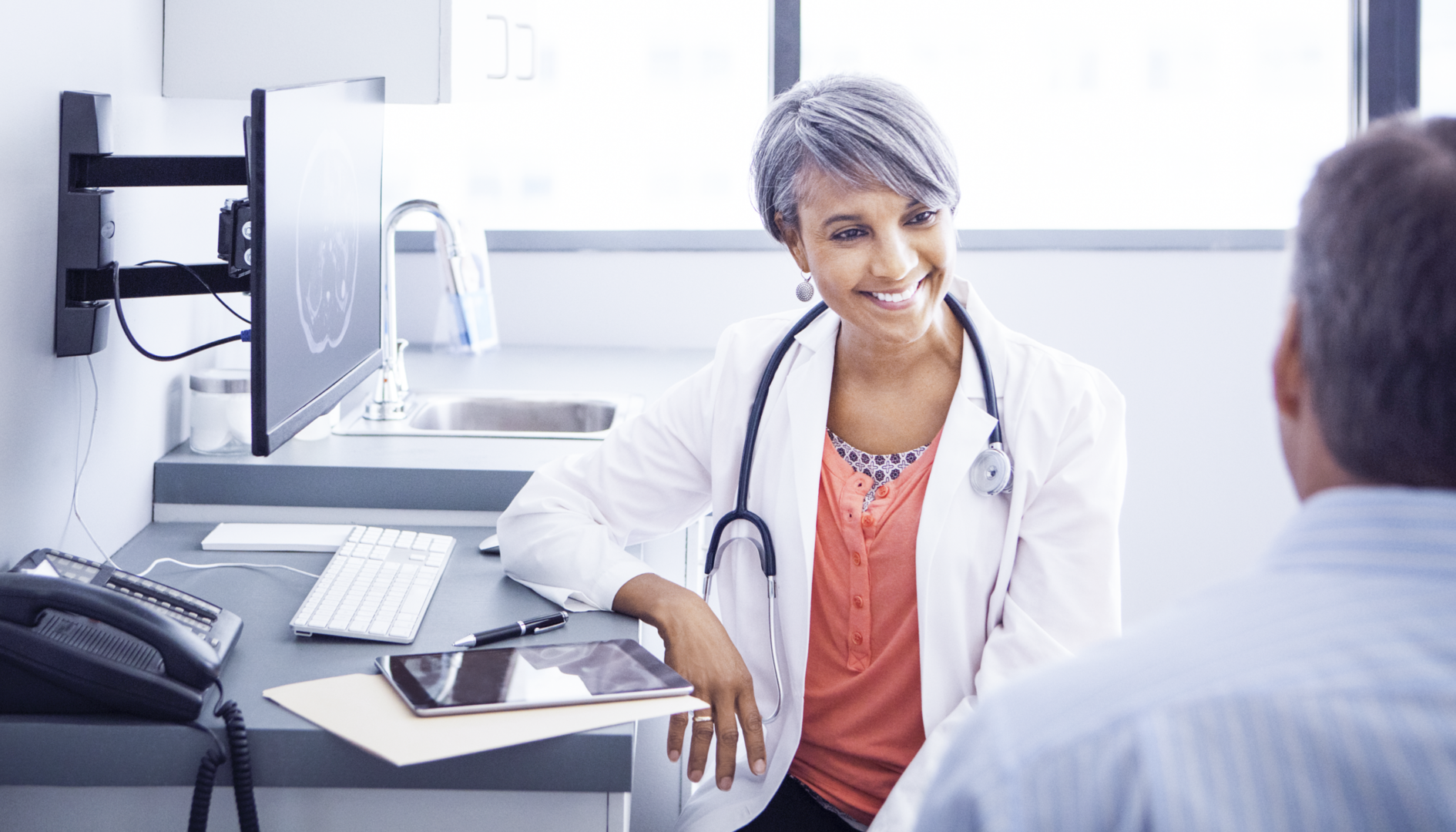 oncology physician in a community specialty practice smiling at a patient